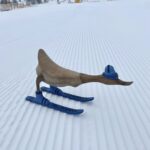 Skiënde eend van hout op de piste.