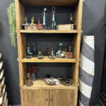 Stoere boekenkast gemaakt van gereycled hout met drie open vakken en opbergruimte met deurtjes.