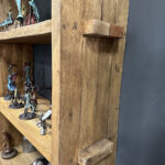 Stoere boekenkast gemaakt van gereycled hout met drie open vakken en opbergruimte met deurtjes.