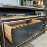 Stoer dressoir van teakhout met vier stoere zwart stalen lades. Tussen het blad en de lades zit een speelse tussenruimte.