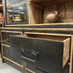 Stoer dressoir van teakhout met vier stoere zwart stalen lades. Tussen het blad en de lades zit een speelse tussenruimte.