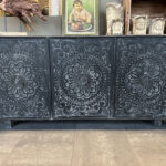 Zwart dressoir met handgesneden mandala's in de deurtjes.