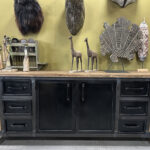 Dressoir Yordi is een stoere kast gemaakt van staal en geleefd hout. De kast bestaat uit zes lades met in het midden opbergruimte achter twee deurtjes.