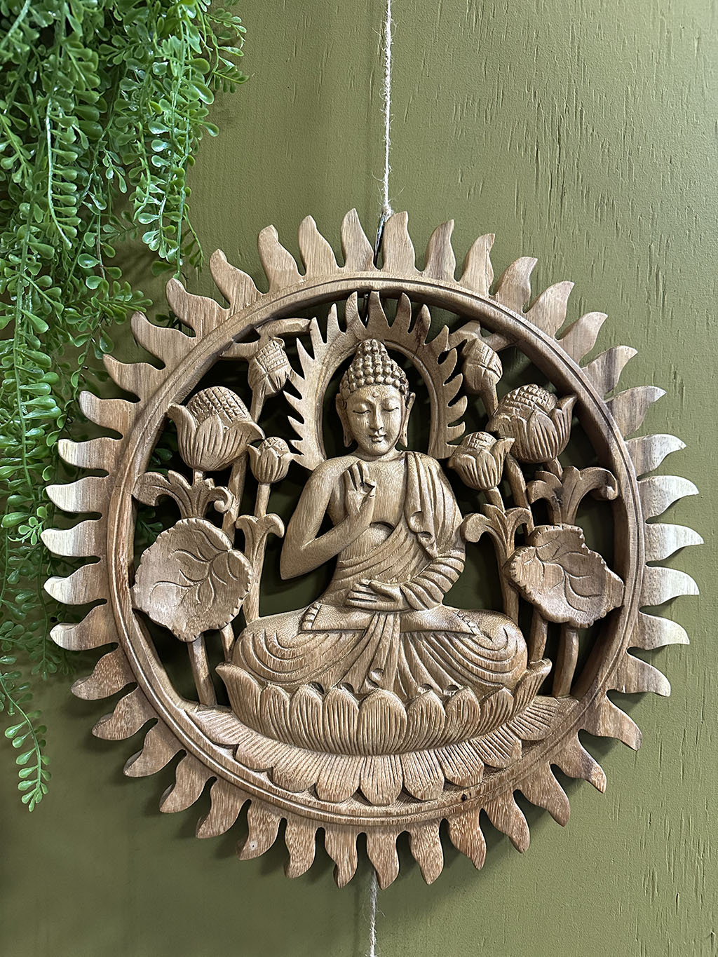 Deze tot in detail uitgesneden ronde houten wandecoratie met een Boeddha in het midden is een pronkstuk aan uw muur. Prachtig uit één stuk hout gesneden!