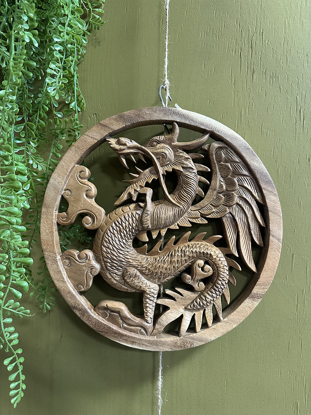 Deze tot in detail uitgesneden ronde houten wandecoratie met een draak in het midden is een pronkstuk aan uw muur. Prachtig uit één stuk hout gesneden!