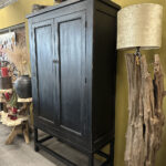 Kabinet in zwarte olie met geleefd uiterlijk op stalen frame.