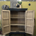 Kabinet in zwarte olie met geleefd uiterlijk op stalen frame.