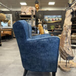 Blauwe relaxfauteuil op houten pootjes.