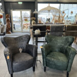 Relaxfauteuil op houten pootjes in groen en zwarte stof bekleed.