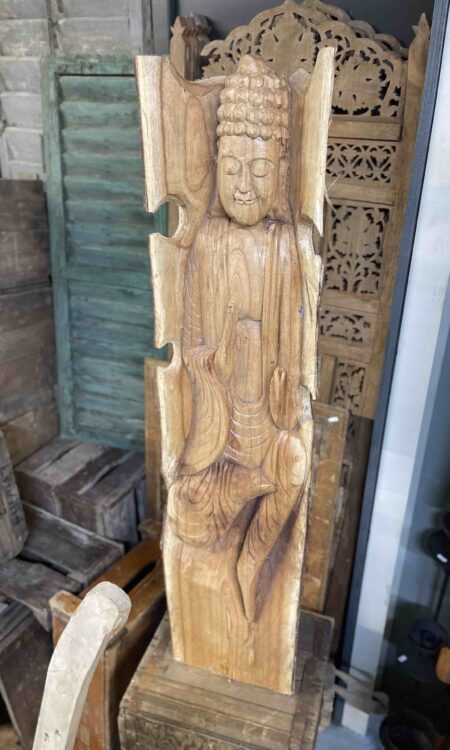 Handgemaakt houtsnijwerk van een boeddha geïntegreerd in een houten stam.