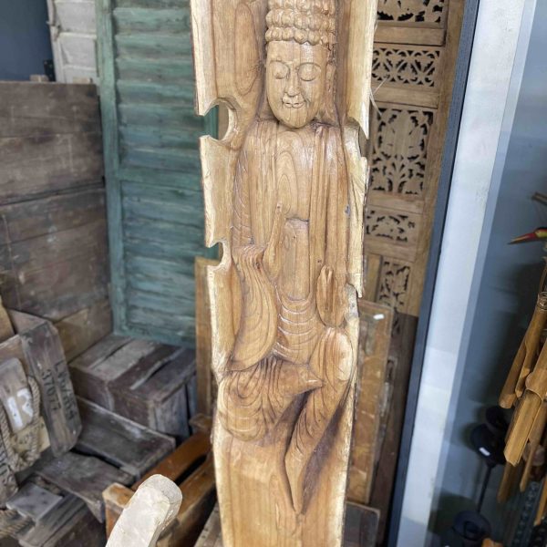 Handgemaakt houtsnijwerk van een boeddha geïntegreerd in een houten stam.