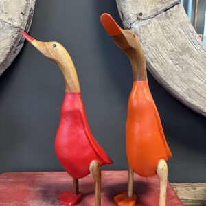 Houten eend in rood en oranje pakje is met de handgemaakt en beschilderd in een rood en oranje pakje