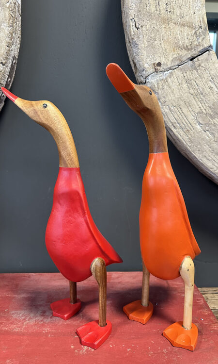 Houten eend in rood en oranje pakje is met de handgemaakt en beschilderd in een rood en oranje pakje