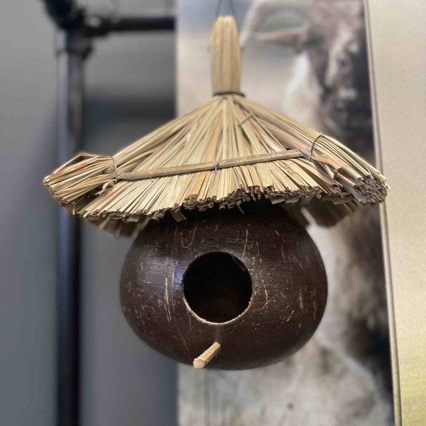 Vogelhuisje gemaakt van kokos met dak van stro.
