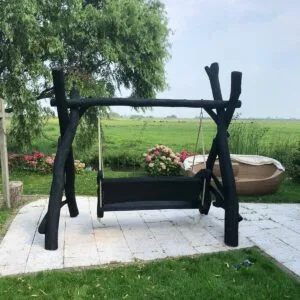 Deze zwarte houten schommelbank is gemaakt van eiken zitgedeelte en acacia palen. Doordat de vormen van de planken organisch zijn heeft elke schommel zijn unieke karakter. De schommel is in een zwarte beschermende olie gezet.