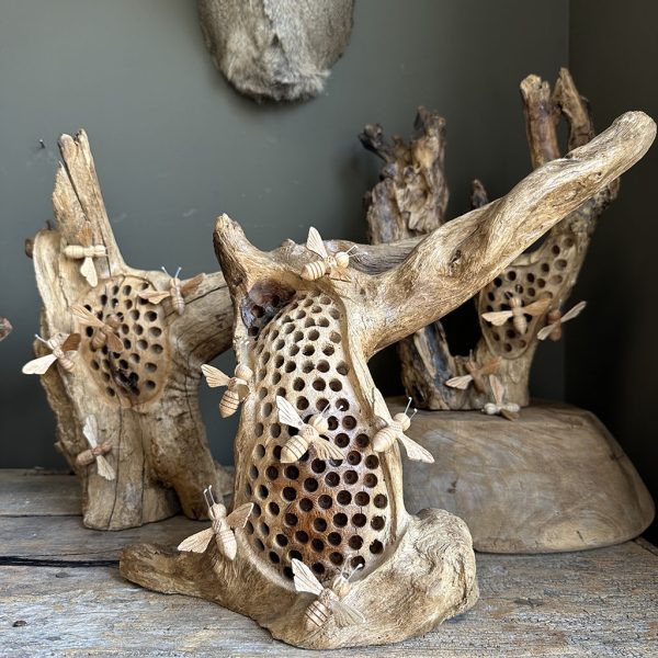 Uniek bijenhotel in natuurlijke houten stronk met handgemaakte bijtjes als decoratief tuinobject.