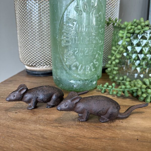 Gietijzeren muisjes in roestbruine kleur als stoere decoratieve woonaccessoires op een houten plank.