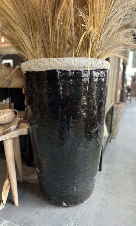 Grote geglazuurde aardewerken pot in donkere kleur als blikvanger voor tuin of interieur.
