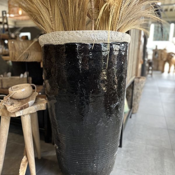 Grote geglazuurde aardewerken pot in donkere kleur als blikvanger voor tuin of interieur.