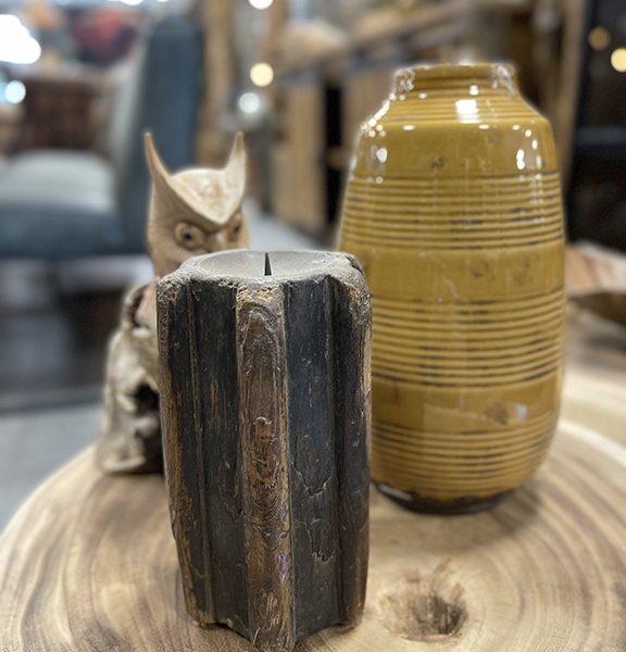 Donkere houten kaarshouder van oud hout op een tafel als stoer decoratief woonaccessoire.