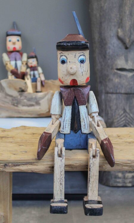 Handgemaakte houten bungelpop in Pinokkio stijl met beweegbare benen, verkrijgbaar in twee maten.