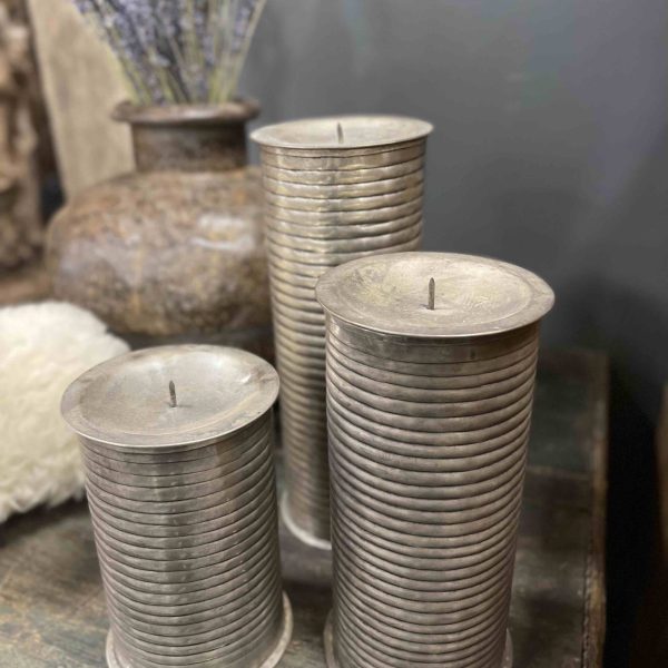 Metalen kandelaars met ribbelstructuur en afneembaar deksel voor het opbergen van een kaars.